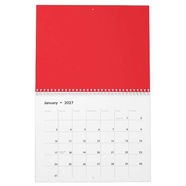 Red and orange crayons lying side by side on a whi calendar (Jan 2027)