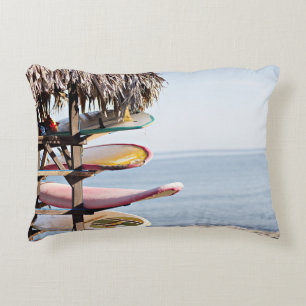 Red and white surfboard in brown wooden rack decorative cushion