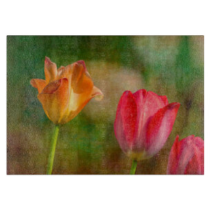 Red and yellow tulips on textured background cutting board