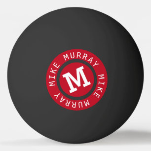 red circle monogram on black ping pong ball