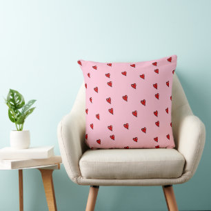 Red glossy hearts on pink cushion