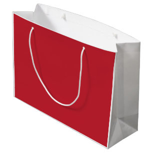 Red, pink, and orange garments hang side by side o large gift bag