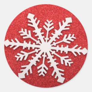 Red snowflake on a red glitter background classic round sticker
