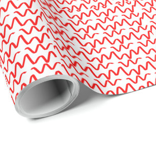 Red wavy carefree ribbons on white wrapping paper