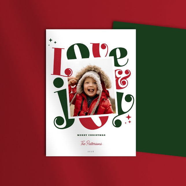 Retro Red and Green Love and Joy 1 photo Christmas Holiday Card (Love and Joy Christmas Holiday Photo card shown with green back pattern on a red table mockup)