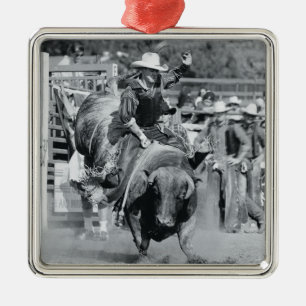Rider hanging on to bucking bull metal tree decoration