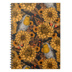Robins in the autumn garden on black notebook