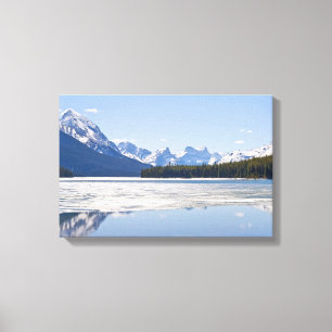Rocky mountains reflecting in Maligne lake Canvas Print
