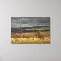 Rolling Hills And Mountains Under A Cloudy Sky