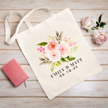Romantic Pink Floral Bouquet Couple Names Tote Bag<br><div class="desc">A lush bouquet of soft pink and coral watercolor blooms with touches of burgundy and fresh greenery adorns this romantic tote with personalised couple names and wedding date curving alongside. A lovely design for wedding welcome bags, day-of favours, or a keepsake gift for the happy couple. All text including names...</div>