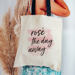 Rosé the Day Away Tote Bag<br><div class="desc">Is there any better way to spend a hot summer Saturday? We think not. Rosé the day away with our cute tote bag for wine lovers,  featuring the quote in black handwritten style brush lettering on a blush pink watercolor wash background.</div>