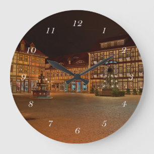 Round wall clock market square Wernigerode at nigh
