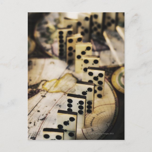 Row of dominoes on old world map postcard (Front)