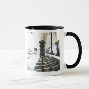 Row of free weights in foreground and exercise mug