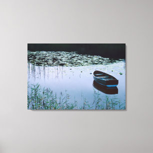 Rowboat on small lake surrounded by water canvas print
