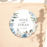 Rustic Boho Dusty Blue Flowers Wedding Classic Round Sticker<br><div class="desc">Introducing our Personalised Wedding Sticker, a harmonious blend of rustic allure and contemporary elegance. This beautifully crafted sticker features a charming watercolor wreath, showcasing a delicate arrangement of neutral and dusty blue flowers. At the heart of this floral embrace, your names are elegantly inscribed in a classic serif font, seamlessly...</div>