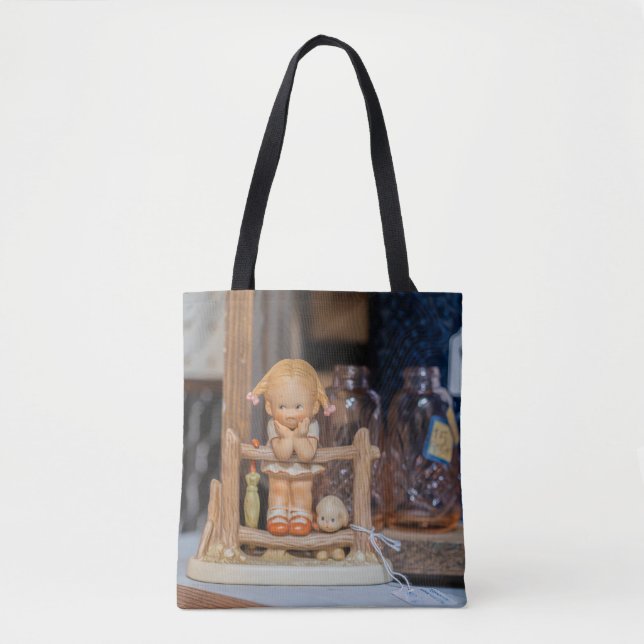 Rustic Charm: Ceramic Doll on a Swing Tote Bag (Front)