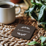 Rustic Dark Brown Wood Laurel Last Name Monogram Coaster<br><div class="desc">This simply elegant custom monogrammed beverage coaster set features leafy laurel branches that frames a family last name. A beautiful keepsake gift for newlyweds or new homeowners. A dark walnut brown faux wood grain background adds a rustic textured look to the design. Classic white serif text can be modified via...</div>