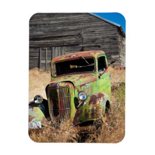 Rusting car in front of abandoned farm magnet