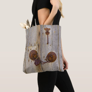 Rusty vintage old iron padlock on a wooden door .. tote bag