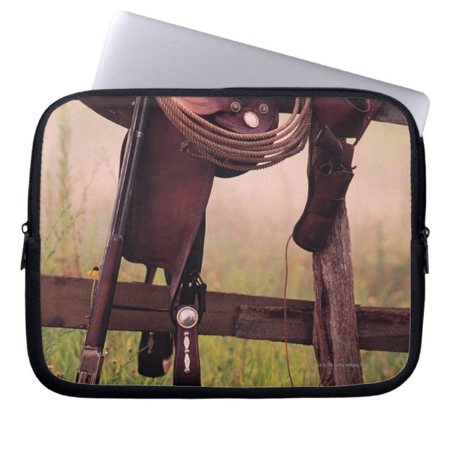 Saddle and lasso on fence laptop sleeve (Front)