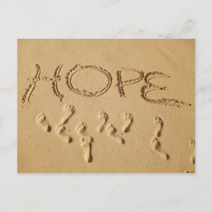 Sand writing ' Hope' on the beach with the Postcard