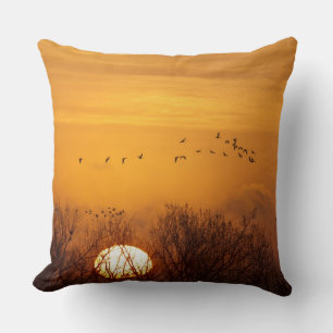 Sandhill cranes silhouetted aginst rising sun cushion