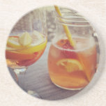 Sangria and Sunshine Coaster<br><div class="desc">This image shows a refreshing glass and pitcher of citrus sangria, perfect for a warm day. The fresh slices of lemon and orange add bright colour and hint of natural sweetness. One glass sits ready to enjoy while sangria is being poured from a small glass pitcher beside it, perfect for...</div>