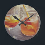 Sangria and Sunshine Round Clock<br><div class="desc">This image shows a refreshing glass and pitcher of citrus sangria, perfect for a warm day. The fresh slices of lemon and orange add bright colour and hint of natural sweetness. One glass sits ready to enjoy while sangria is being poured from a small glass pitcher beside it, perfect for...</div>