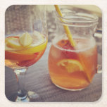 Sangria and Sunshine Square Paper Coaster<br><div class="desc">This image shows a refreshing glass and pitcher of citrus sangria, perfect for a warm day. The fresh slices of lemon and orange add bright colour and hint of natural sweetness. One glass sits ready to enjoy while sangria is being poured from a small glass pitcher beside it, perfect for...</div>