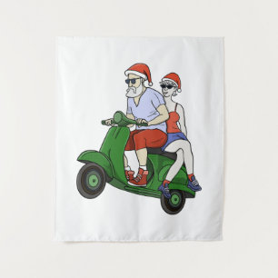 Santa and Mrs. Claus riding a scooter Tapestry