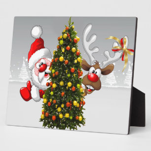 Santa claus and reindeer behind a christmas tree.j plaque
