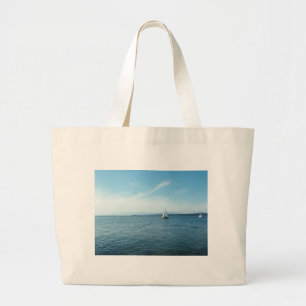 sea and sail boat under blue sky large tote bag