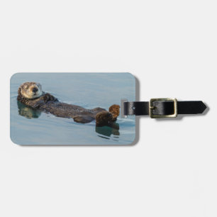 Sea otter floating on back in ocean luggage tag