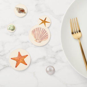 Sea oyster shells, stars & pearl on ivory table confetti