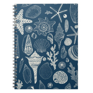 Sea shells on dark blue notebook