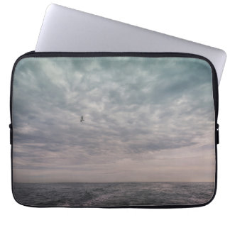Seagull flying under a cloudy sky laptop sleeve