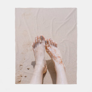 Selective focus photography of feet with tattoo on fleece blanket