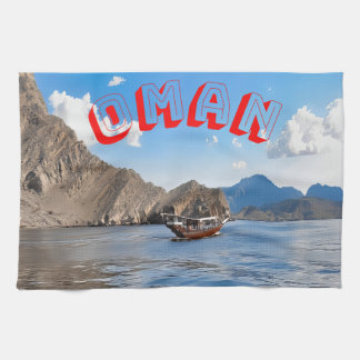 Serene waters and majestic Omani mountains Tea Towel
