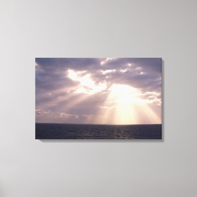 Setting sun shining through clouds over ocean canvas print (Front)