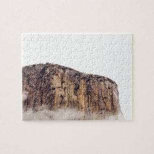 Sheer cliff rising above clouds jigsaw puzzle