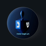 Shiny Blue Dreidel 6 Cm Round Badge<br><div class="desc">A modernistic,  metallic blue dreidel against a dark,  night-like background.  Two of the Hebrew letters found on a dreidel,  nun and shin,  glow brightly.  Hebrew text reading "Chag Chanukkah Sameach" (Happy Hanukkah) also appears in glowing blue and white.</div>