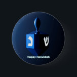 Shiny Blue Dreidel 6 Cm Round Badge<br><div class="desc">A modernistic,  metallic blue dreidel against a dark,  night-like background.  Two of the Hebrew letters found on a dreidel,  nun and shin,  glow brightly.  Text reading "Happy Hanukkah" also appears in glowing blue and white.</div>