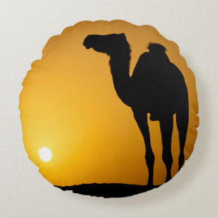 Silhouette of a wild camel at sunset round cushion