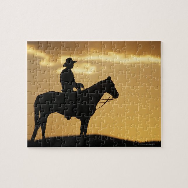 Silhouette of cowboy on horseback at sunset or jigsaw puzzle (Horizontal)