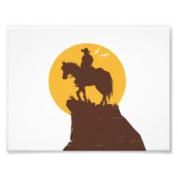 Silhouette of cowboy riding horse at sunset