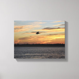 Silhouette of pelican flying over the river canvas print