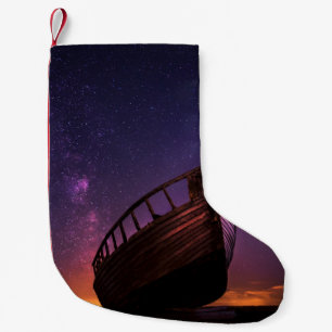 SILHOUETTE PHOTOGRAPHY OF SAILING BOAT ON BODY OF SMALL CHRISTMAS STOCKING