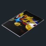 SlipperyJoe Hanukkah symbolic still life holiday e Notebook<br><div class="desc">SlipperyJoe Hanukkah symbolic still life holiday essence vibrant meaningful objects colourful slender pile menorah candles artistic red blue yellow and white sufganiyah doughnut classic jelly-filled commemorate miracle of the oil dreidels metallic gold glossy blue Hebrew great miracle happened there metallic pewter star of David medallion light resilience community themes spiritual...</div>