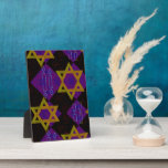 SlipperyJoe's Hanukkah-themed image golden yellow  Plaque<br><div class="desc">SlipperyJoe's Hanukkah-themed image golden yellow Star of David blue candles with orange flames Menorah-inspired art gift idea Jewish identity spirituality holiday retro bold symmetrical pattern diamond-shaped grid background blends tradition and vibrant design purple black chequerboard effect Hebrew religious celebration</div>